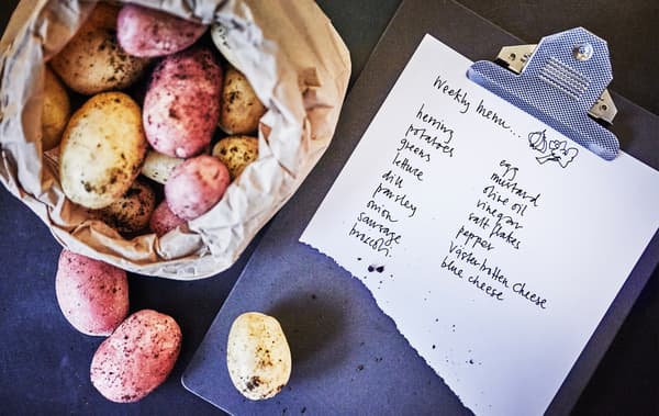 Gros plan d’un sac de pommes de terre et d’une liste de courses.