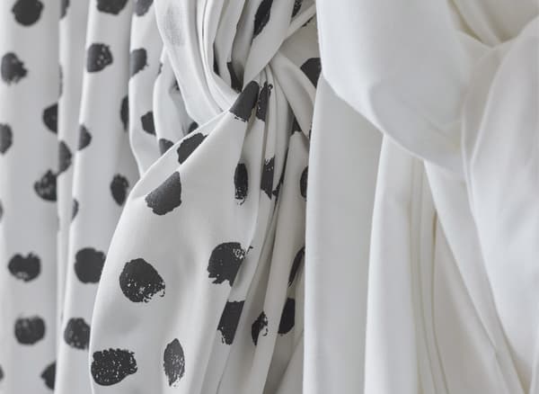 Gros plan d’un tissu à motif et d’un tissu uni drapés.