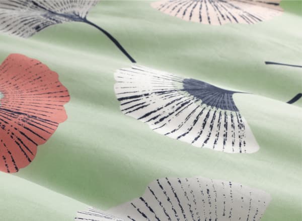 Gros plan d’un tissu vert pâle orné d’un motif floral.
