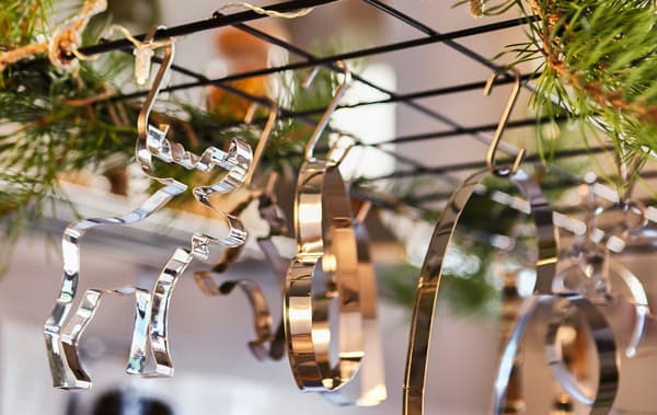 Gros plan d’un treillis installé au-dessus d’un îlot de cuisine et décoré avec de la verdure et des emporte-pièces pour biscuits.