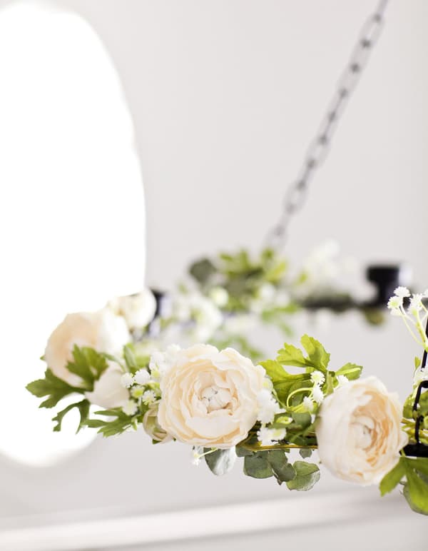 Gros plan d’une guirlande de fleurs décorative, en vert et blanc.