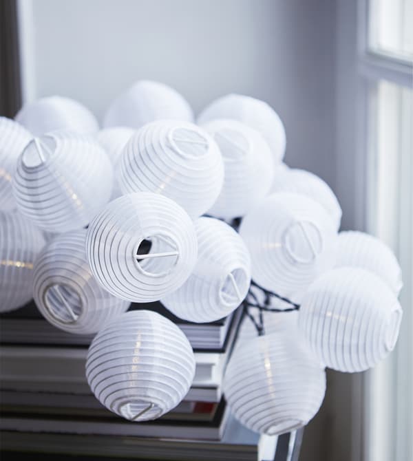 Gros plan d’une guirlande lumineuse composée de mini-lanternes.