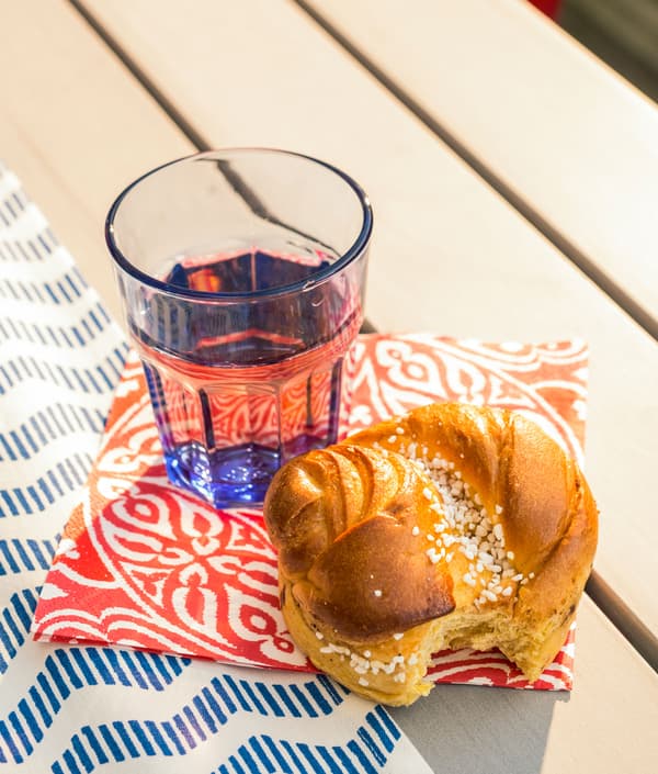 Gros plan d’une pâtisserie et d’un verre de jus sur le plateau d’une table.