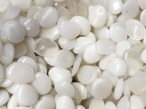 Gros plan sur des fragments de plastique PLA blancs et transparents, fait de matériaux renouvelables.