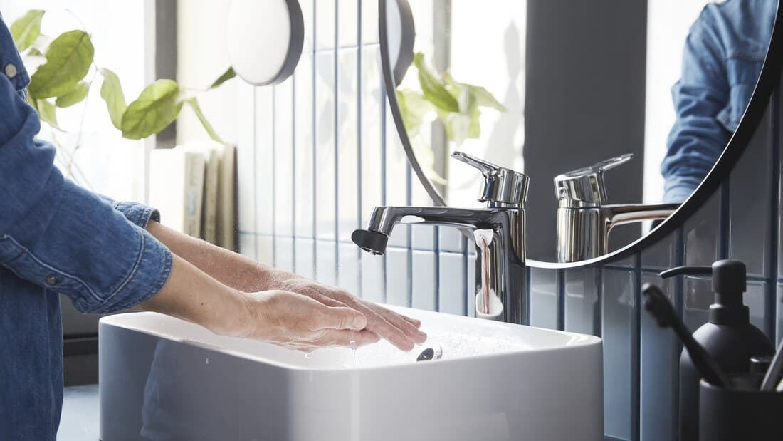 Gros plan sur des mains qui se frottent avec du savon sous un robinet