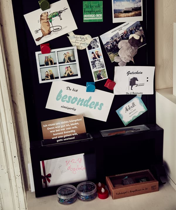 Gros plan sur des photos et des notes épinglées sur un tableau noir.