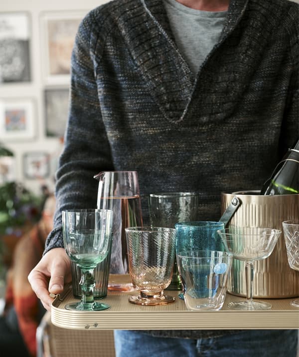 Gros plan sur un homme portant un plateau rempli de verres.
