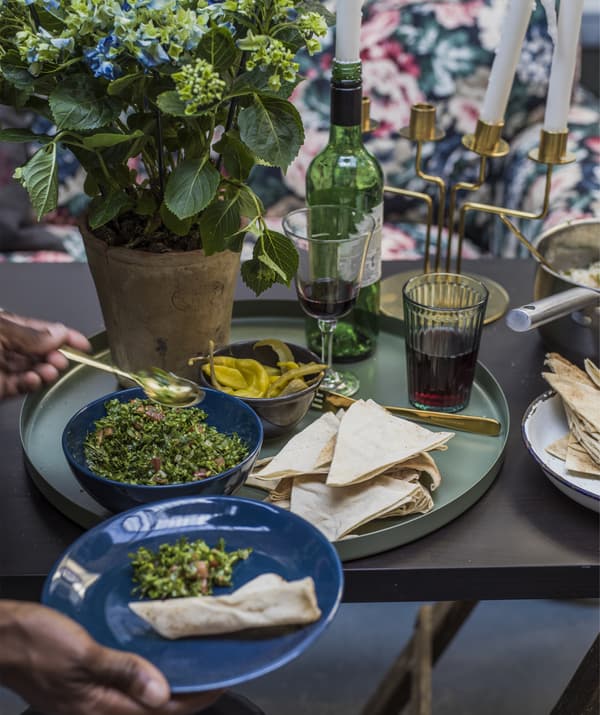 Gros plan sur une table à manger, un plateau vert et des bols de nourriture.