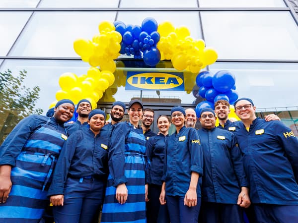 group of ikea co-workers in blue uniform in front of the store entrance