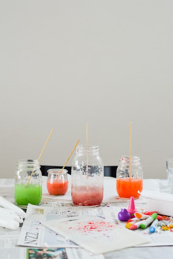 Grüne, orange und rosa Wachsfarbe in Glasbehältern, auf einem Tisch