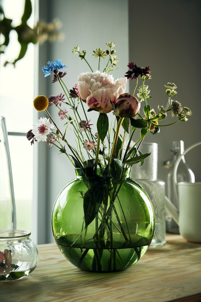 Grüne Vase mit Frühlingsstrauß.