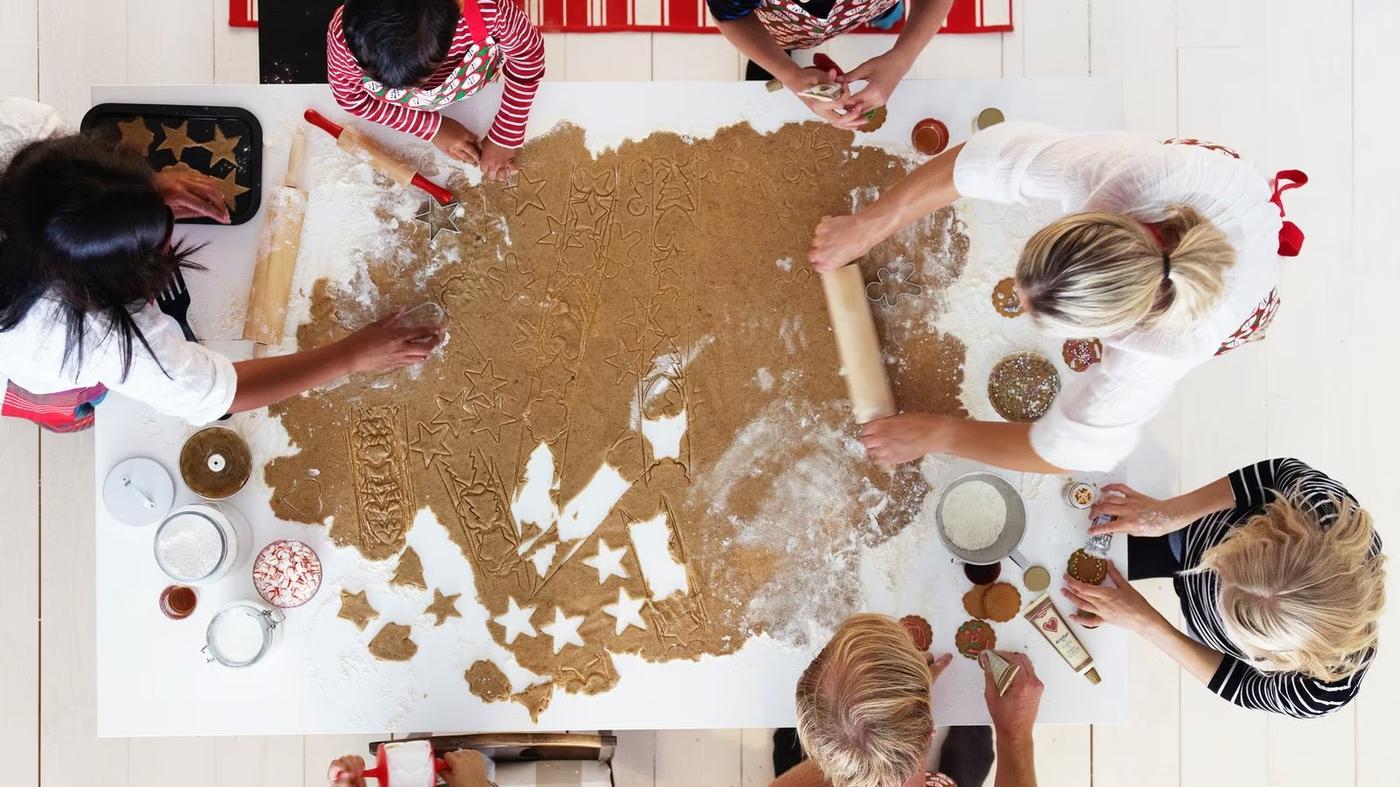 grupa osób wspólnie robi świąteczne pierniki