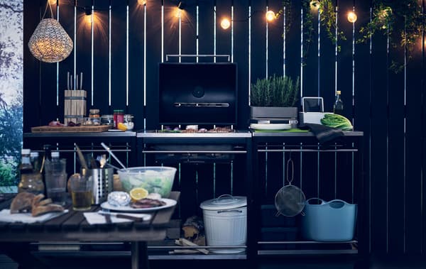 Guirlande lumineuse suspendue au-dessus d’une cuisine d’extérieur.