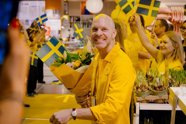 Gulklädda IKEA-medarbetare med flaggor i förgrunden varuhuschefen