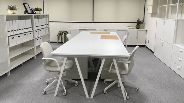 グレーのカーペットが敷かれ、白で統一されたオフィス家具が並ぶ。