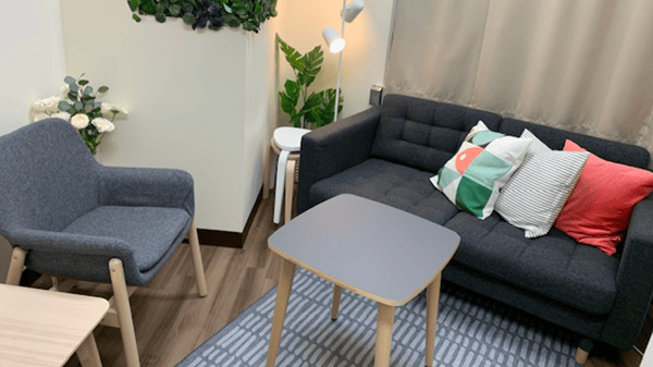 グレーのソファが並び、カラフルなクッションが置かれている。
