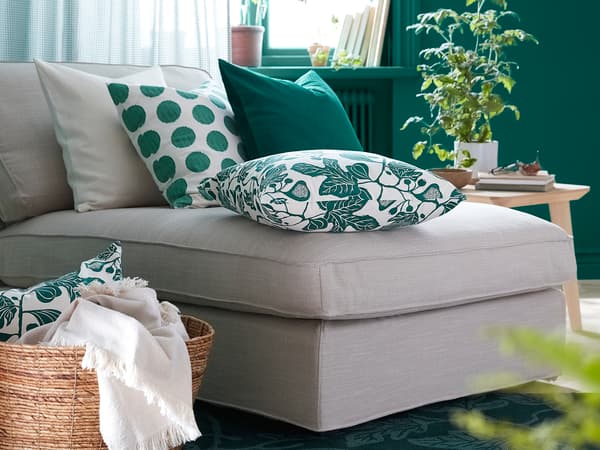 グレーのソファに緑の柄クッションを合わせたリビング。ラタンバスケットと観葉植物で爽やかな雰囲気。