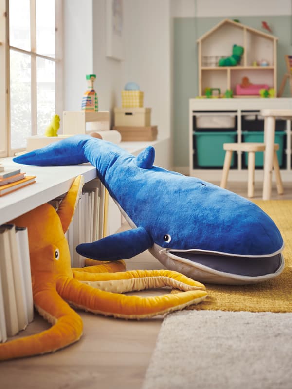 Gyerekszoba, benne két puha játék: egy sárga polip és egy kék BLÅVINGAD bálna.
