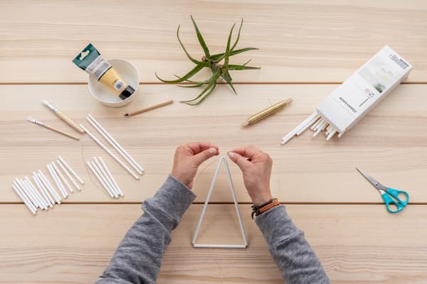 Hände binden das erste Dreick zusammen.