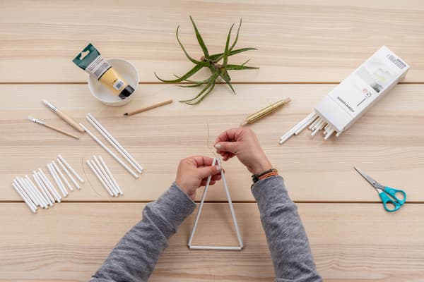 Hände binden das erste Dreick zusammen.