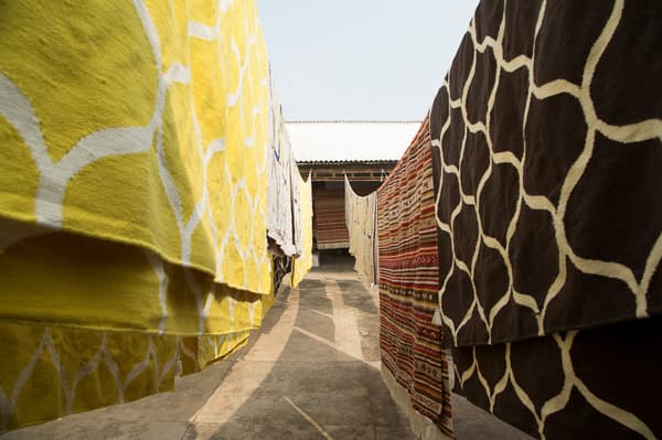 Hand-made rugs hanging to dry at in IKEA weaving centre.