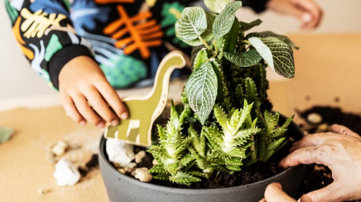 Hand of child playing near a vase.
