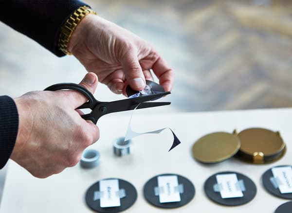 Hands clipping out paper discs to create a party game.