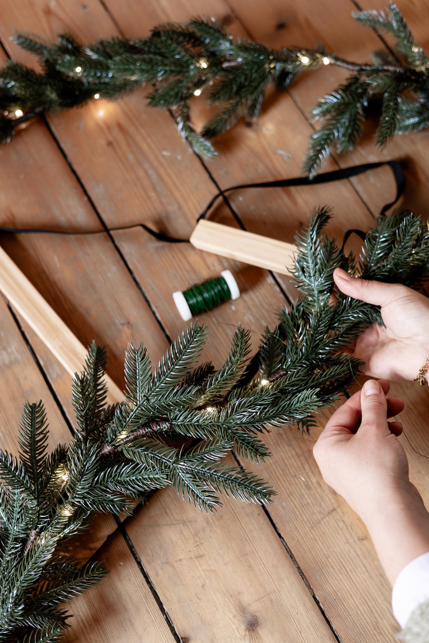 Hands measuring the length of a Christmas chain.