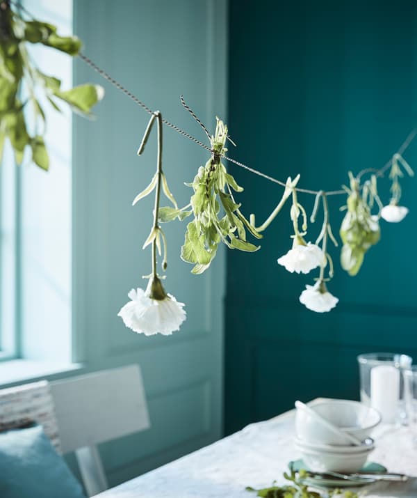 Hang a ribbon above the dining table and decorate it with flowers. Try IKEA GIVANDE ribbon in a mix of beige and black.