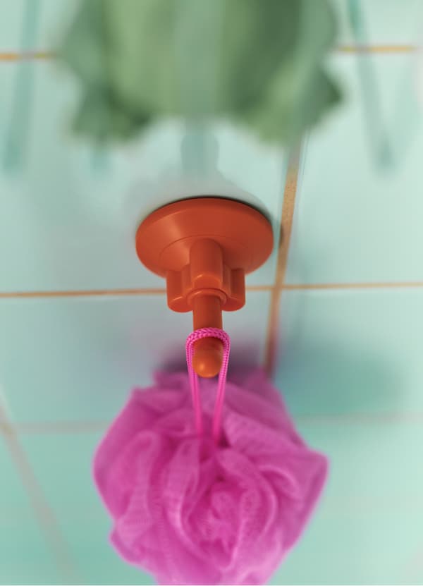 Hang puffs or lightweight items with IKEA LÅDDAN suction cup holder in a bright red orange colour. Its rubber cup and plastic hanger keep things in place.