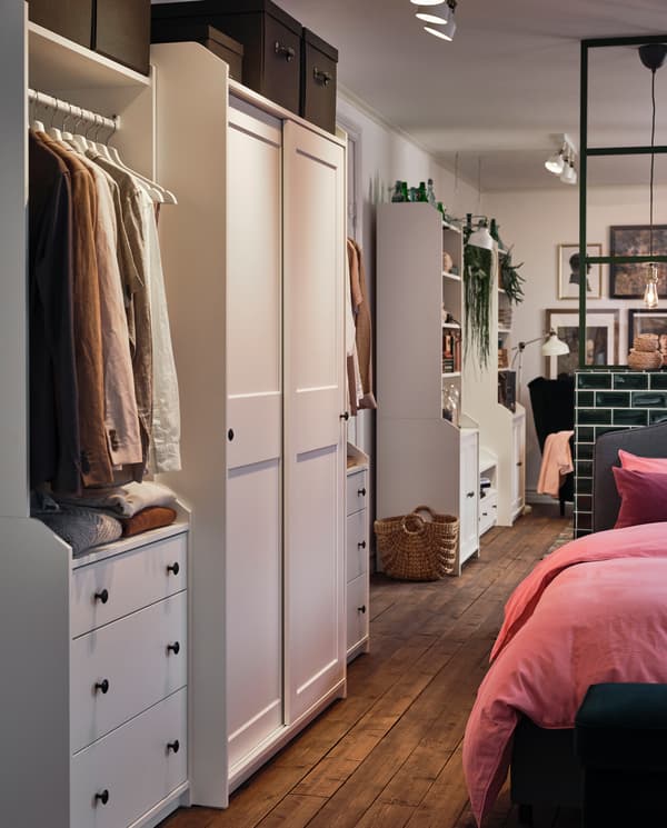 화이트 색상의 HAUGA 하우가 옷장 콤비네이션은 침대 곁에, HAUGA 하우가 TV/수납콤비네이션은 방안 깊숙이 놓여 있는 모습.