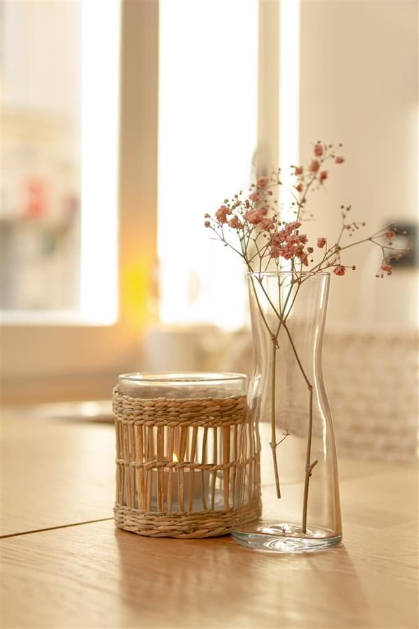 Helle Teelichthalter und Vase als Tischdekoration im Café