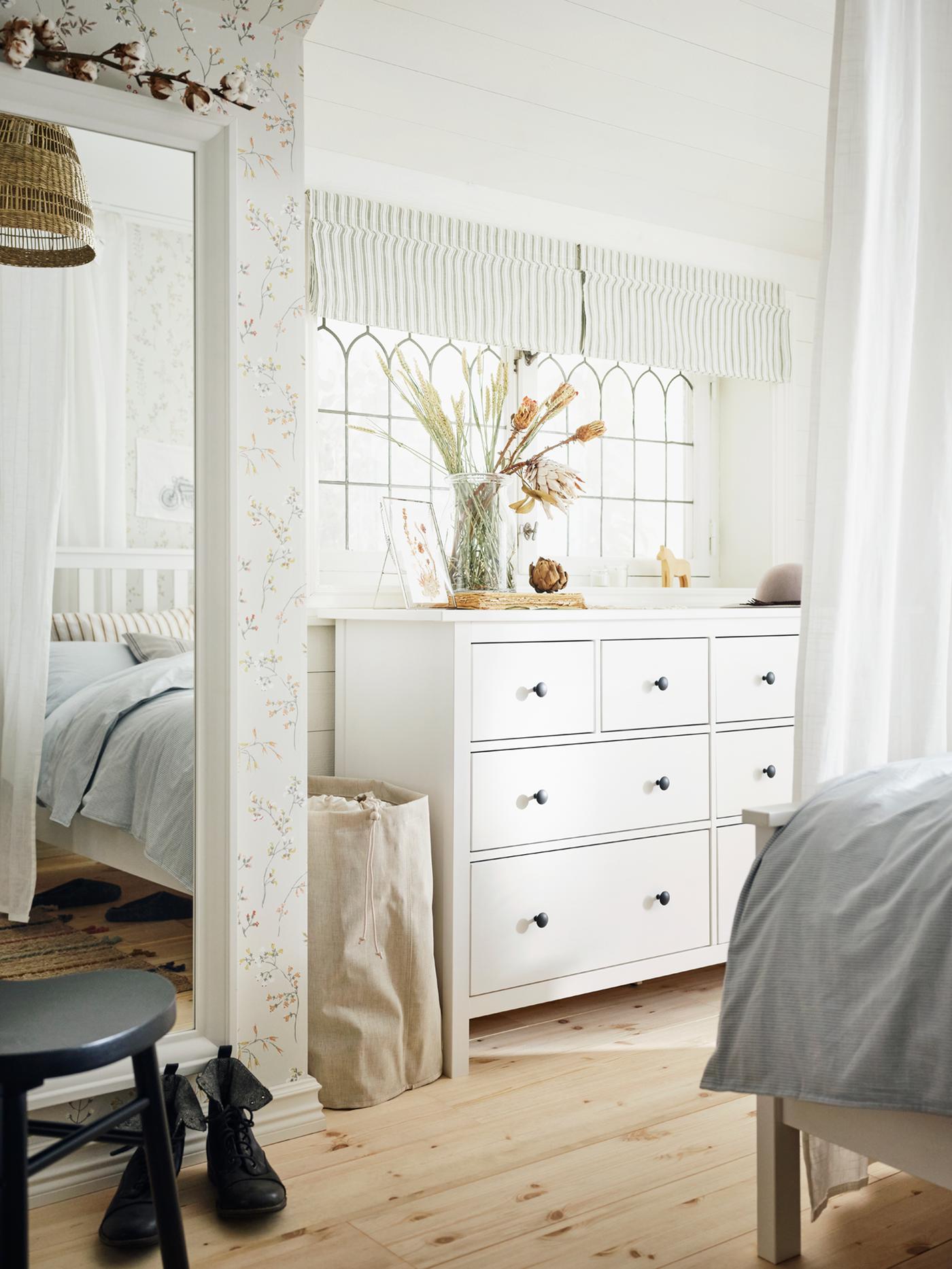 화이트 스테인 HEMNES 헴네스 8단서랍장과 화이트 스테인 HEMNES 헴네스 침대가 목재 바닥과 페일 컬러로 꾸며진 침실에 있는 모습.
