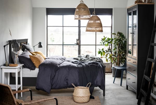 ห้องนอนและเตียง HEMNES/เฮมเนส สีเข้มตั้งอยู่กลางห้อง, หน้าต่างสไตล์ French ที่ผนังด้านหนึ่ง และรายละเอียดของวัสดุและสีธรรมชาติ