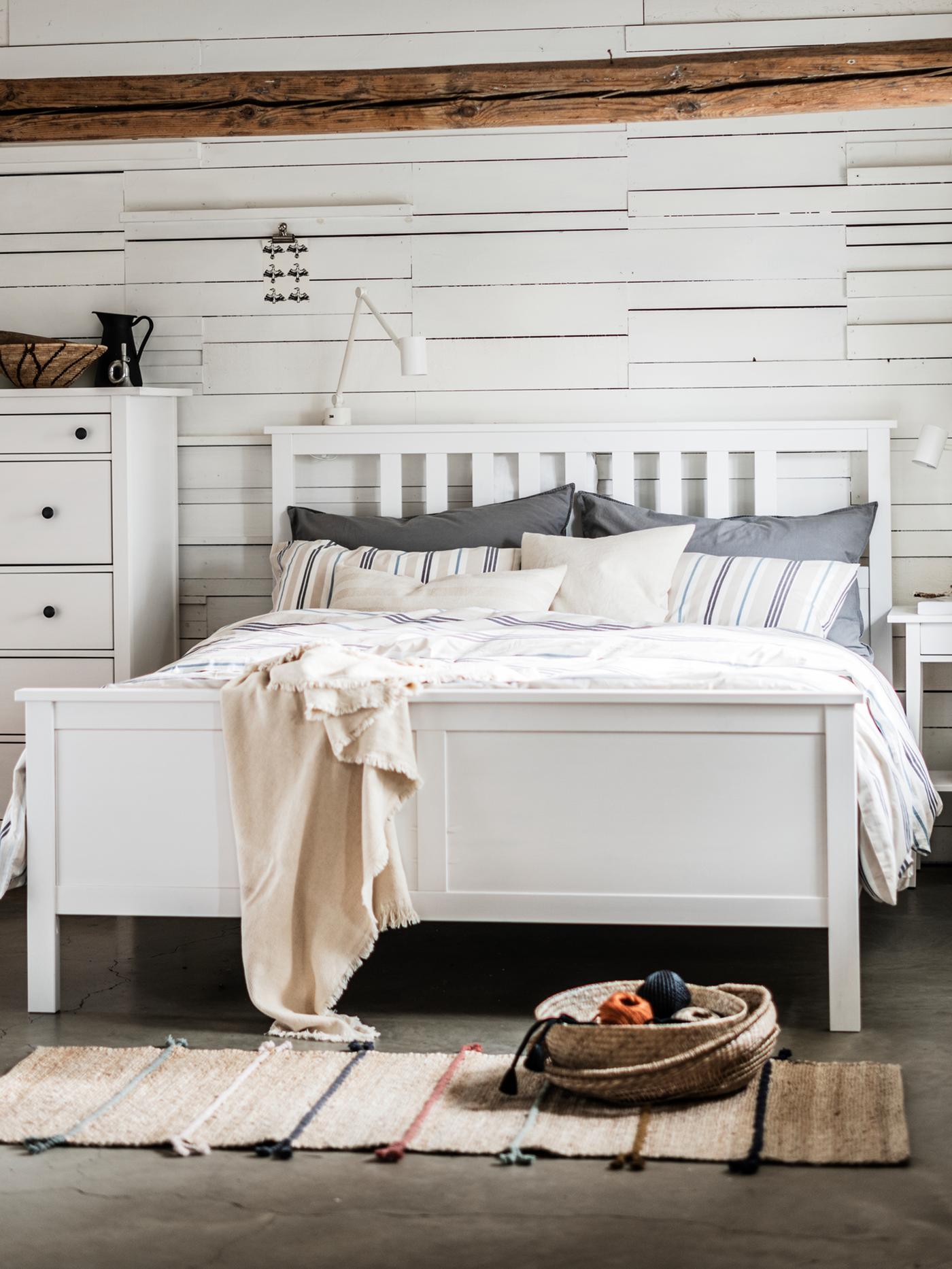 HEMNES tweepersoonsbed staat in een slaapkamer tegen een muur naast een HEMNES ladekast met 6 lades.