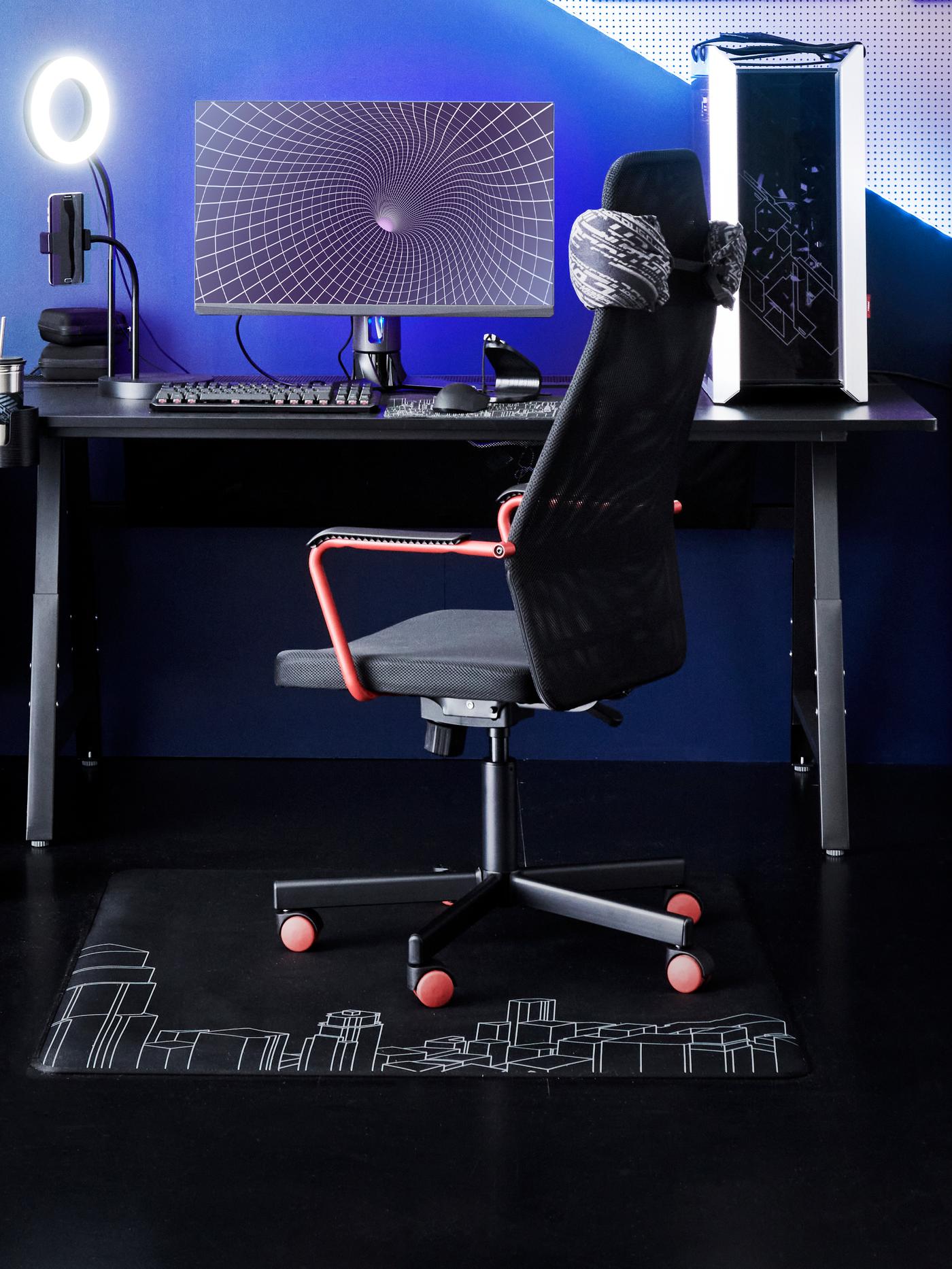 Herní sestava s černou židlí, stolem a příslušenstvím.