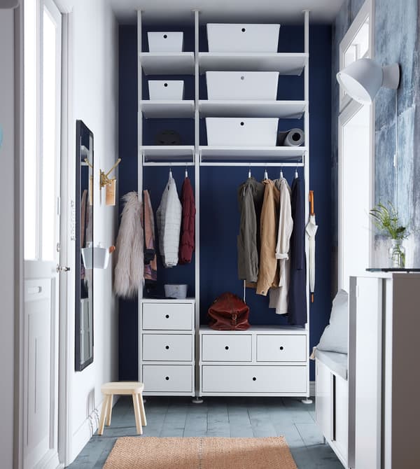 High gloss white KUGGIS boxes inside a white wardrobe system in a hallway.