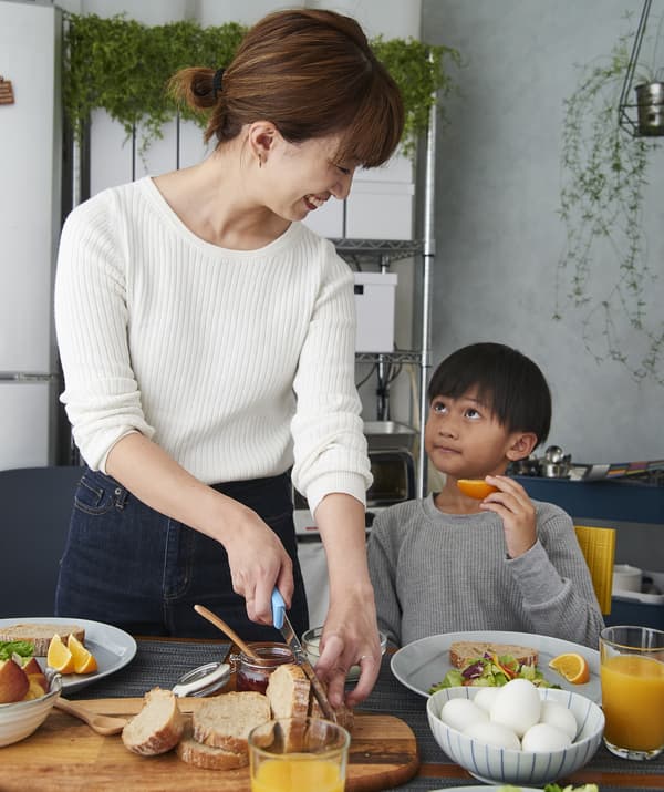 Hiromi e suo figlio preparano la colazione al tavolo.