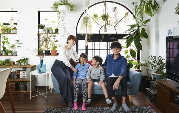 ภาพของ Hiromi และ Shunsuke และลูกของพวกเขานั่งอยู่บนโซฟาและมีต้นไม้แสดงอยู่ที่หน้าต่างด้านหลัง