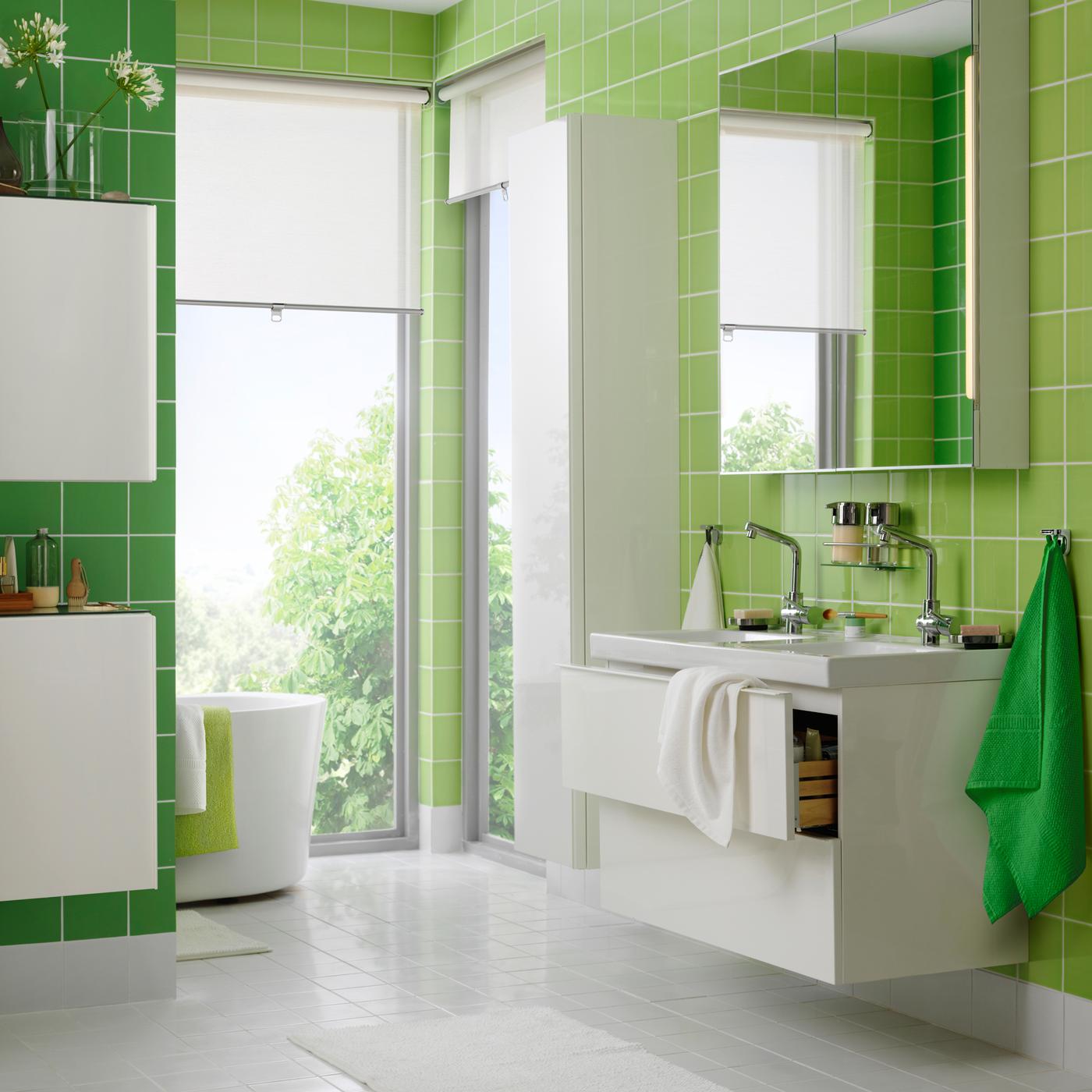 حمام أخضر وأبيض به مغسلة مزدوجة مع درجين.