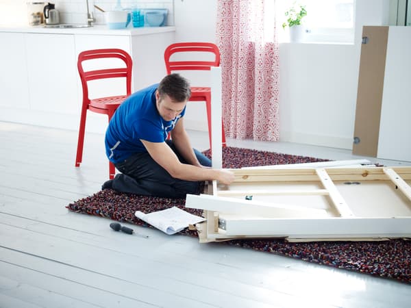 Hombre leyendo instrucciones para armar un mueble IKEA.