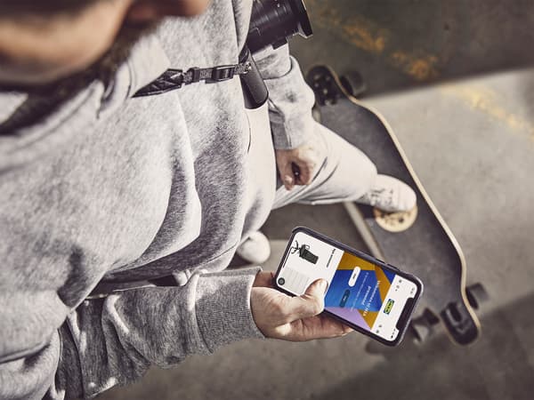 Homem a ver no telemóvel app IKEA Preowned