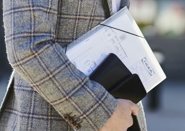 Homme en train de porter des documents dans un porte revue.