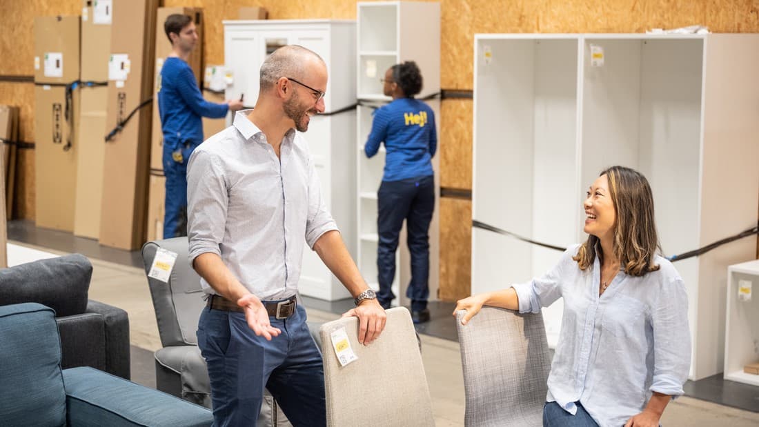 Homme et femme souriant discutant autour de chaises de l'espace seconde vie d'un magasin IKEA