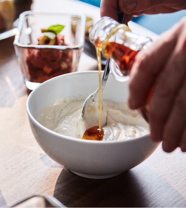 Honey is stirred into yogurt and tahini to make a sauce.