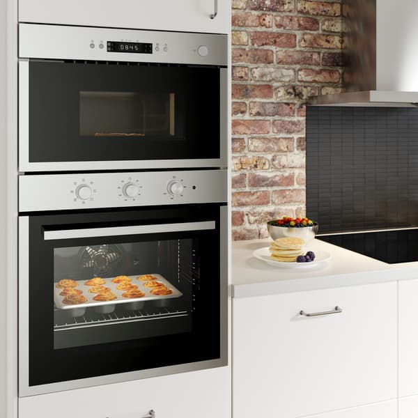 horno dentro de mueble en cocina blanca con pared de ladrillo
