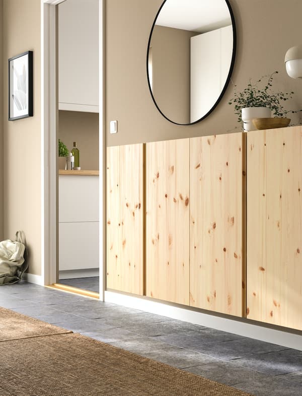 Houten IVAR kasten in een hal met een ronde spiegel erboven