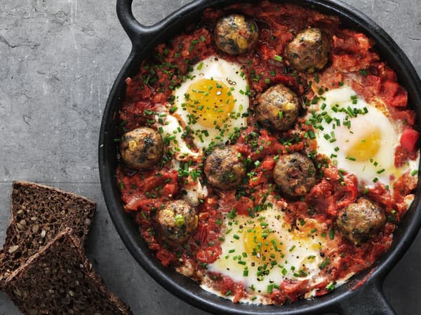 Huevos rancheros s vegetariánskými kuličkami v pánvi.