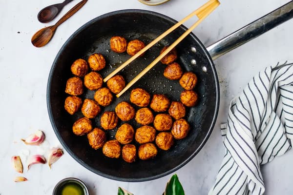 HUVUDROLL Erbsenproteinbällchen werden in einer Pfanne gebraten.