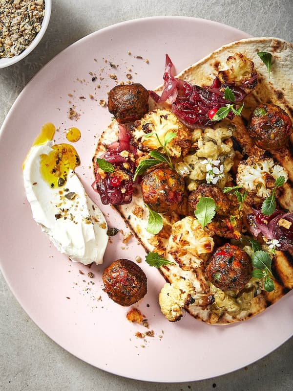 HUVUDROLL zöldséges golyókat látunk zöldségek társaságában egy rózsaszín tányéron.